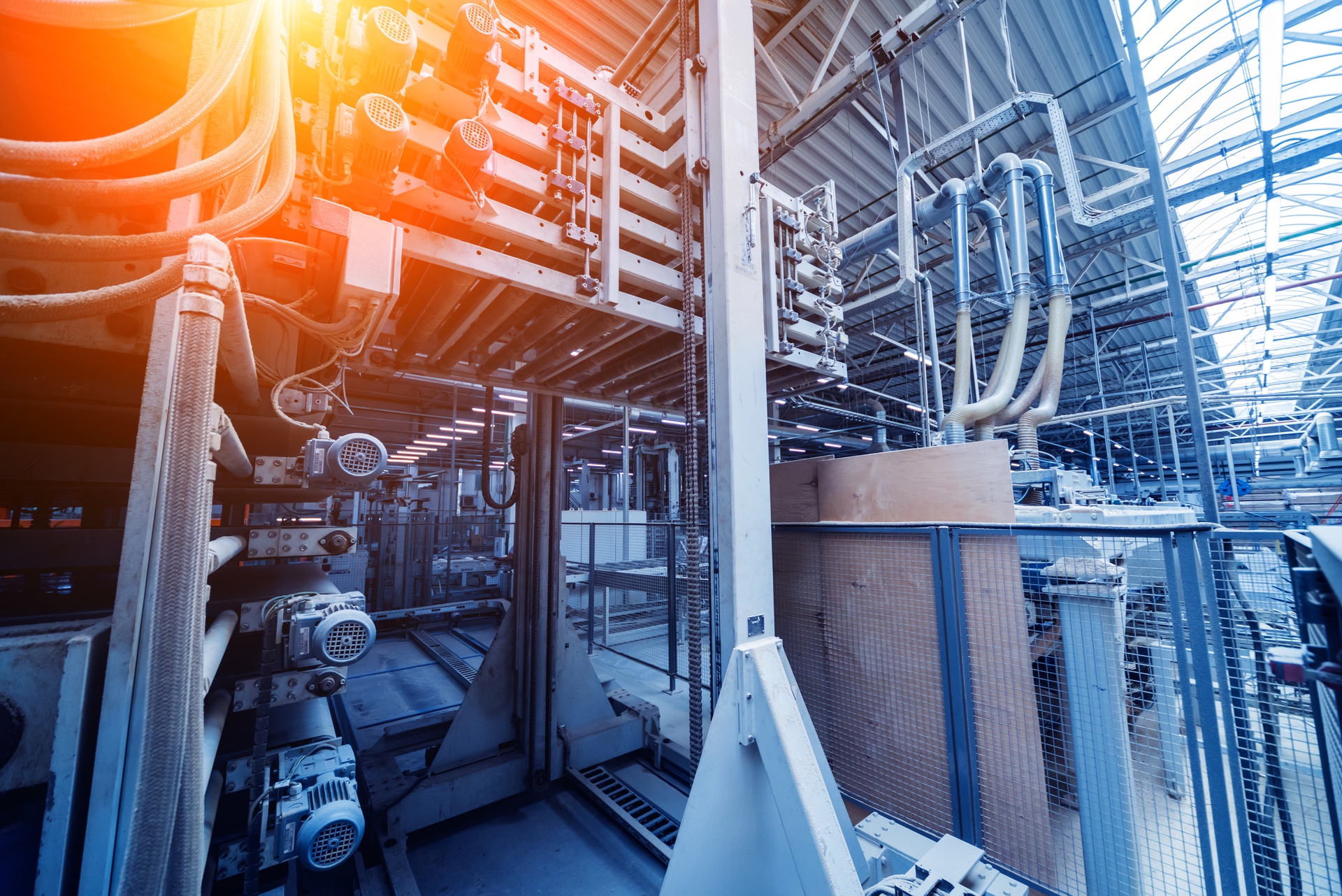 Industrial rooms with machines and cables arranged for production. Bright lighting and modern equipment.