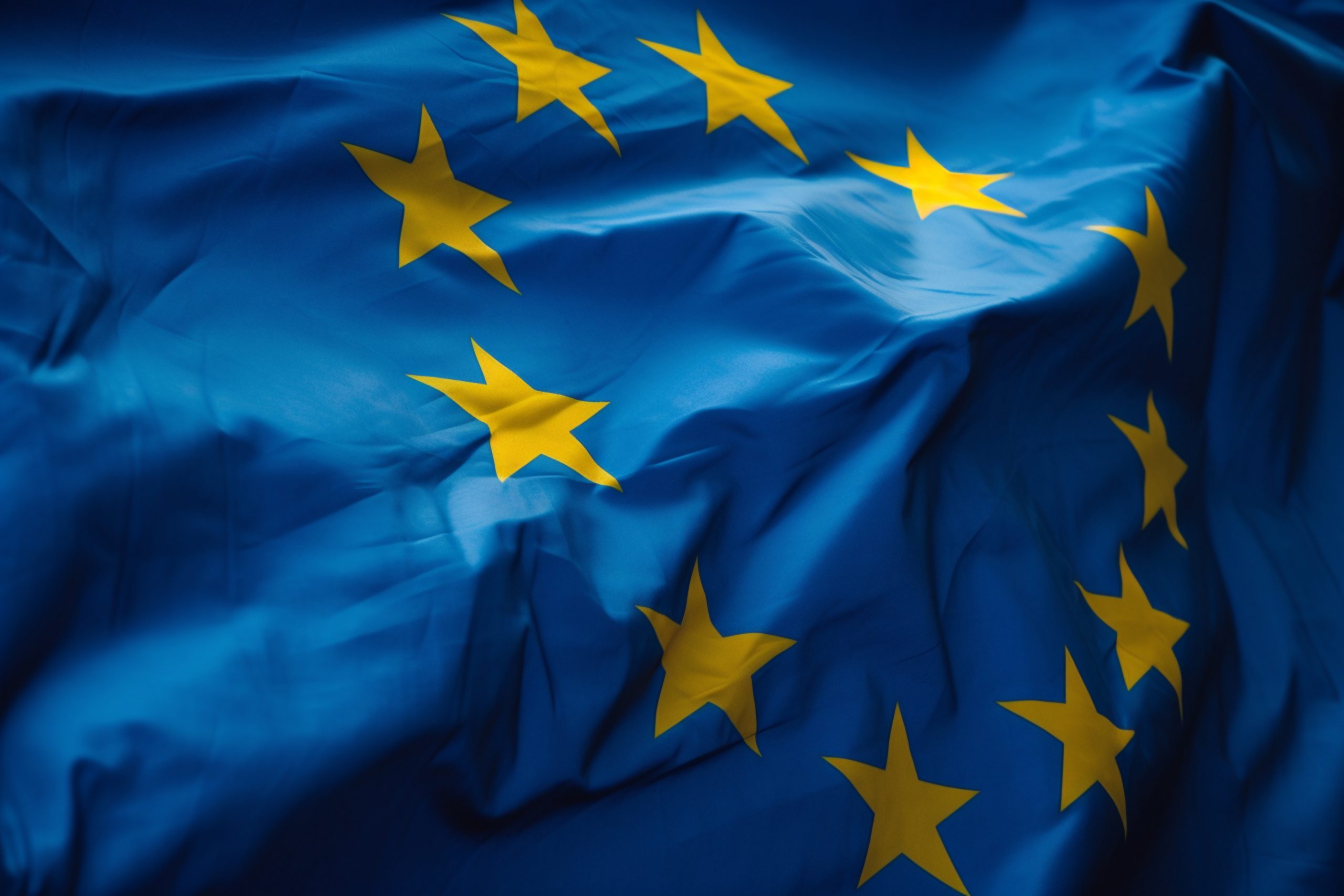 Waving blue European flag with yellow stars, symbol of the European Union.